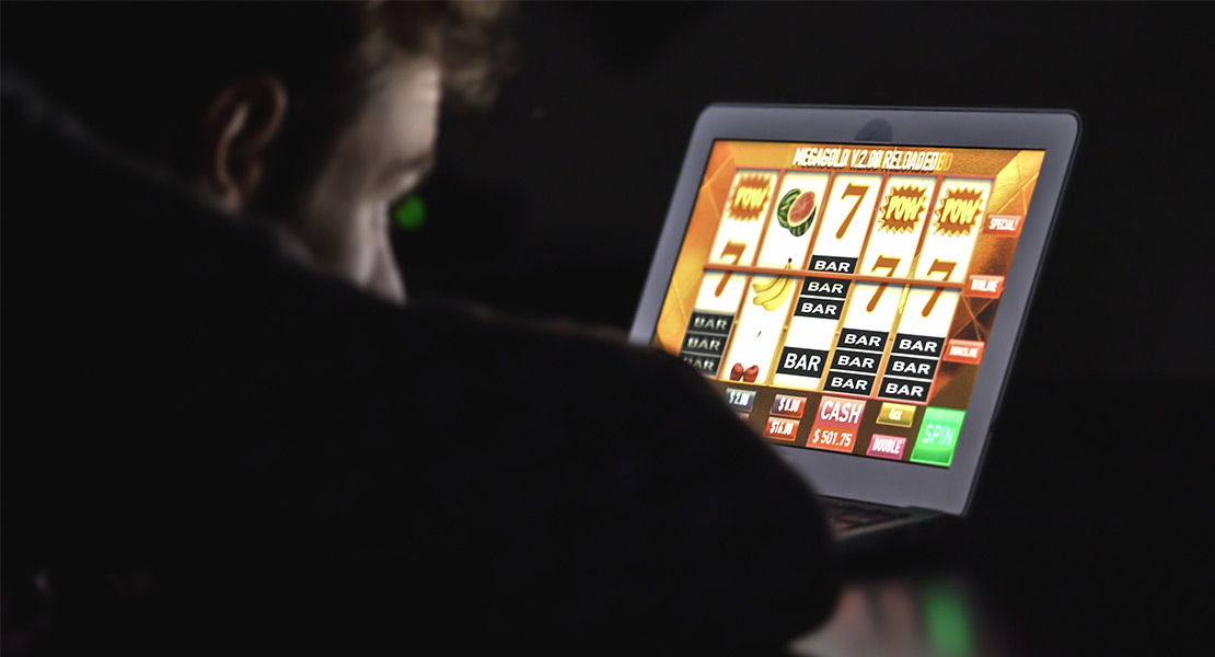 Man spelar slots på laptop